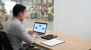 Manajer logistik memantau integrasi WMS ERP dan TMS melalui laptop